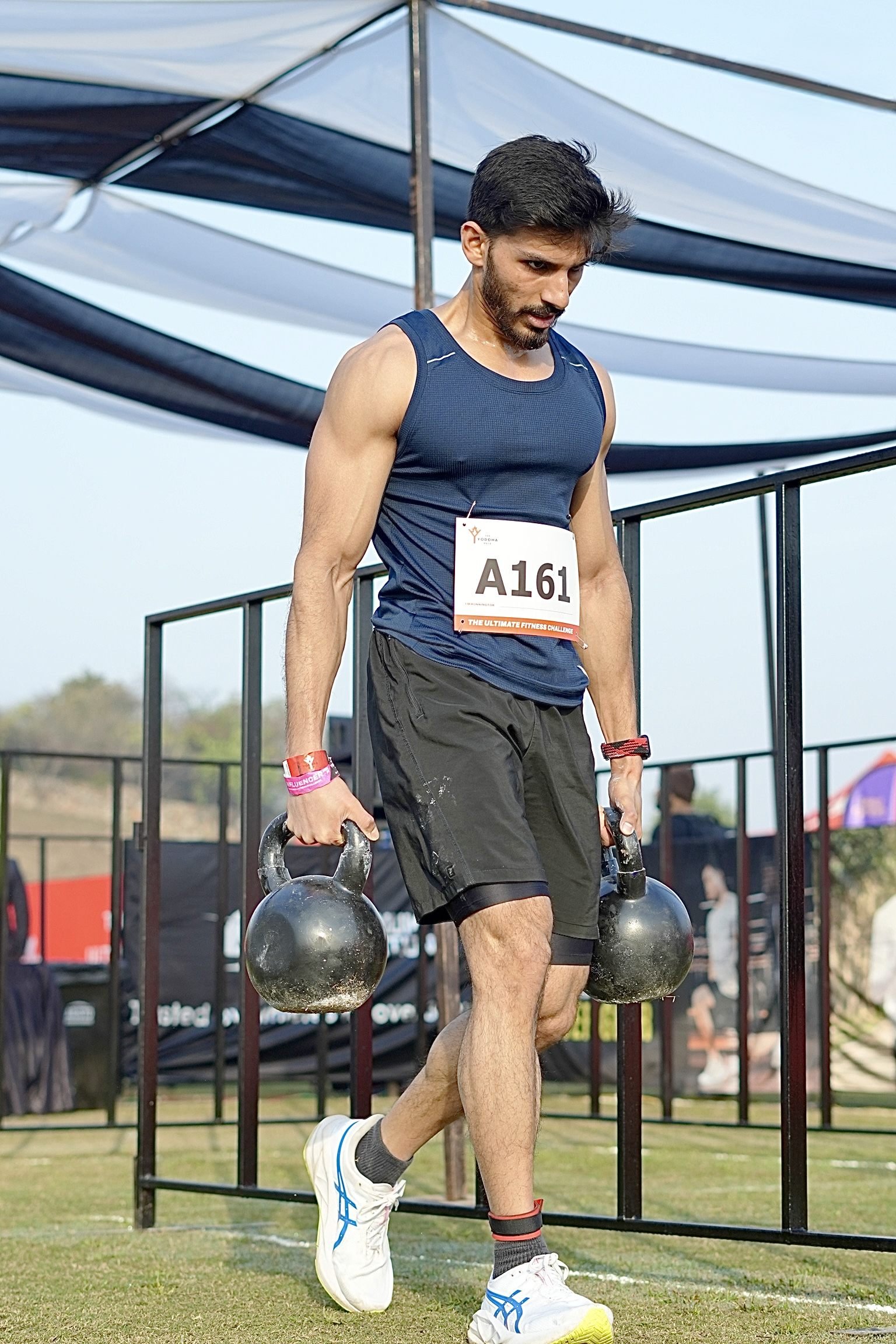 Siddharth Rana carrying kettlebells during a hybrid race